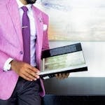 A businessman in a pink suit holding a book, symbolizing success and professionalism.