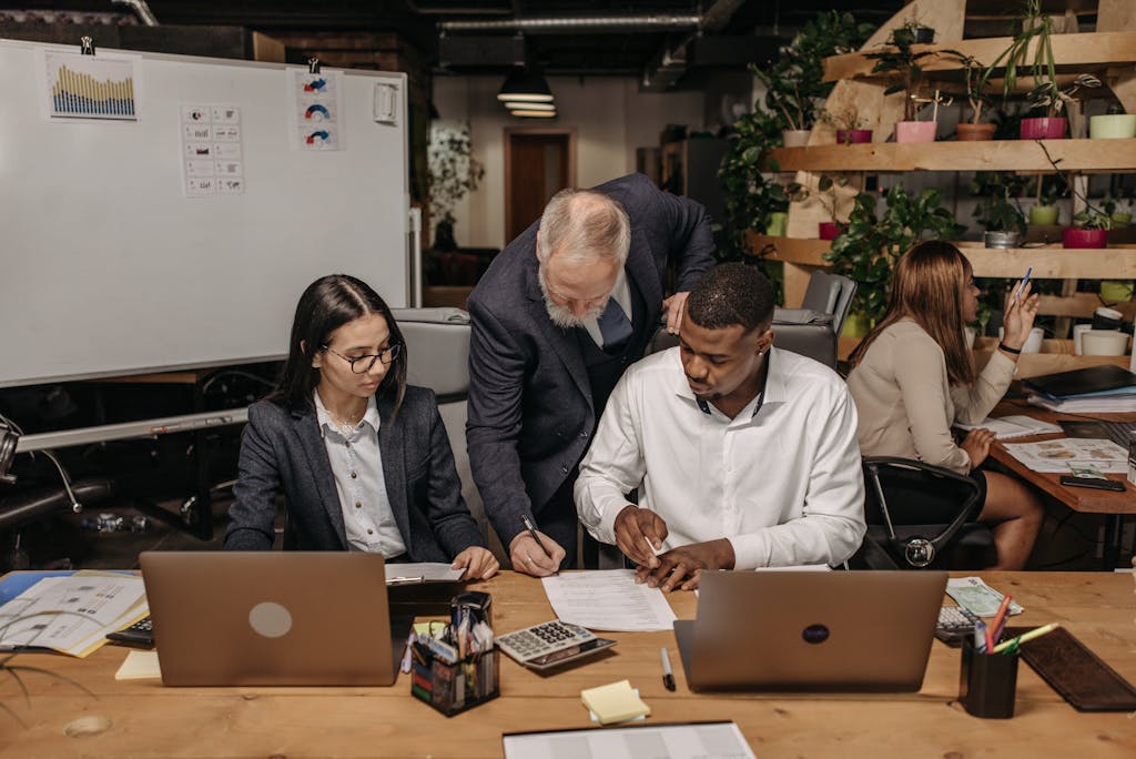 Business team working together with laptops in a collaborative office setting.
