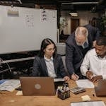 Business team working together with laptops in a collaborative office setting.